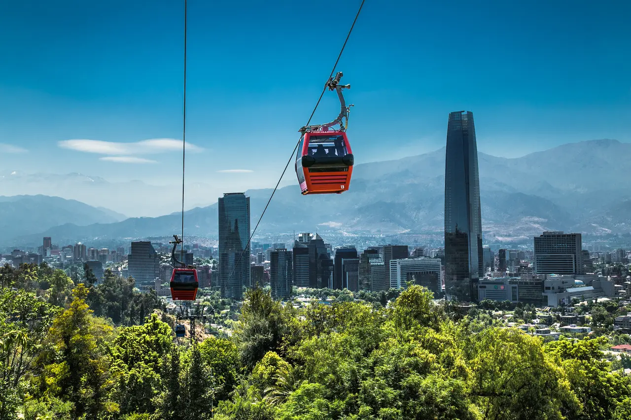 Cabinas rojas del teleférico sobre el Cerro San Cristóbal y la ciudad